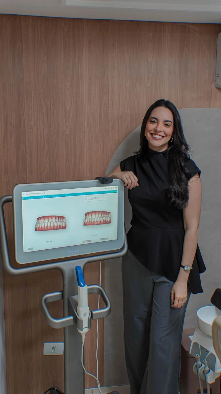 Dra. Manuela ao lado do scanner iTero Element exibindo o simulador de resultados Invisalign